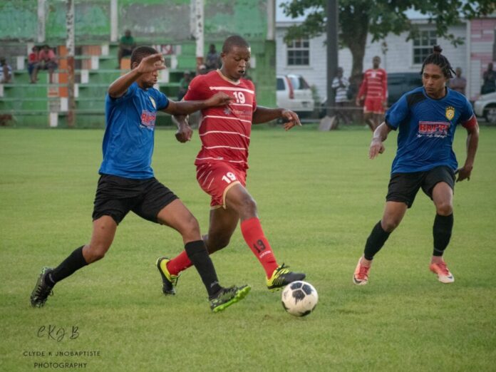 Center Sham Delgue (red shirt) Pointe Michel FC on an attack