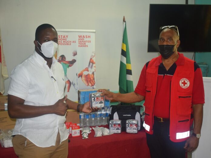 Red Cross President Reginald Winston hand over supplies