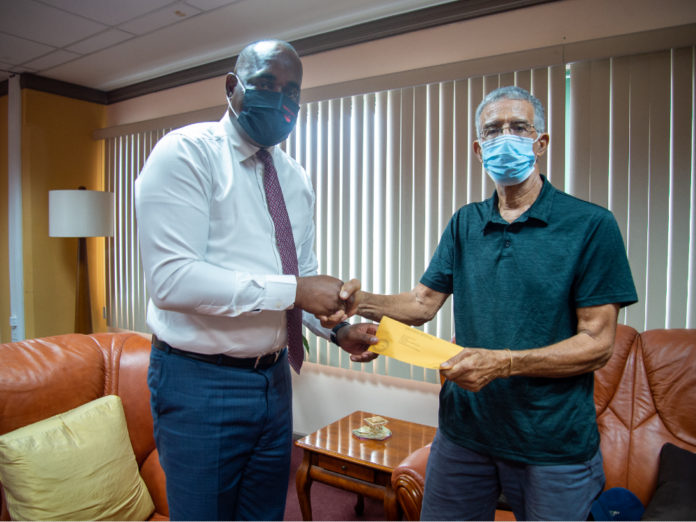PM Skerrit present cheque to Manager of South East Ron Green