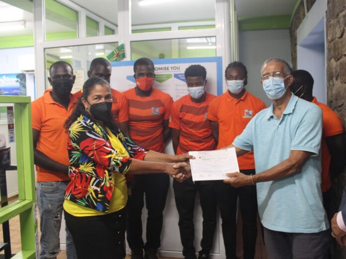 Cheryl Rolle of Sagicor Life hands cheque to Ron Green