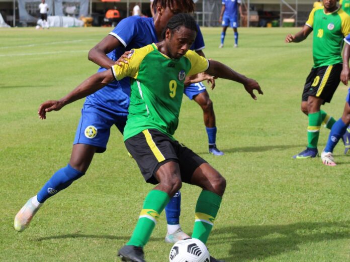 St Lucian player (blue) attacking Dominica