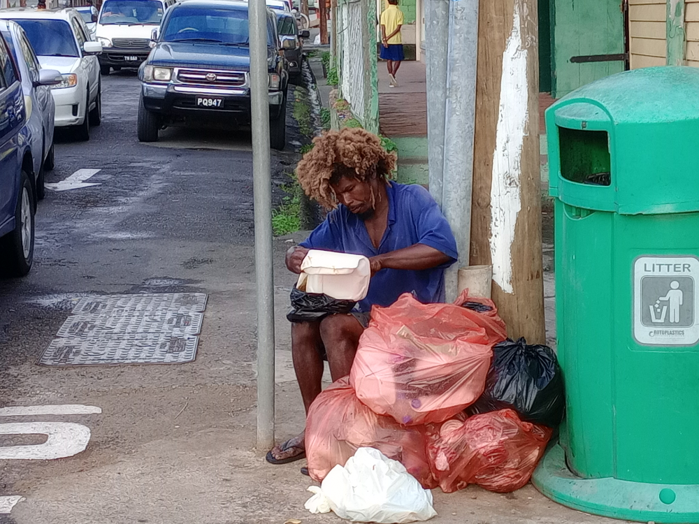 Vagrant eating from garbage
