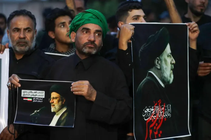 Iraqis carry portraits of Iran's late President Ebrahim Raisi outside the Iranian embassy in Baghdad during a condolences service on May 20, 2024 for the president and his entourage, who were killed in a helicopter crash in Iran the previous day. (Photo: AFP)