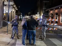 Members of the National Guard and police speak with tourists at a blocked off street, a block from Bourbon Street, after at least 15 people were killed during an attack early in the morning on January 1, 2025 in New Orleans, Louisiana. A US army veteran with an Islamic State flag and "hellbent" on carnage steered a pickup truck into a crowd of New Year revelers in New Orleans on January 1, killing at least 15 people and wounding dozens, officials said. The FBI identified the attacker as Shamsud-Din Jabbar, a 42-year-old US citizen from Texas. (Photo by ANDREW CABALLERO-REYNOLDS / AFP)