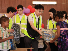 Mr Hu hands out school supplies to students