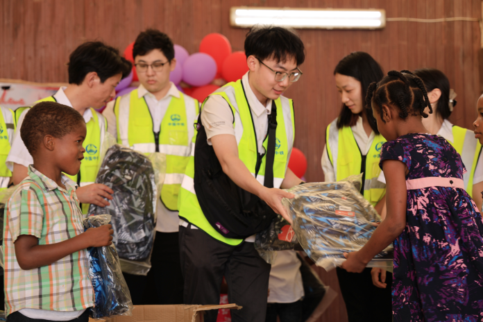 Mr Hu hands out school supplies to students