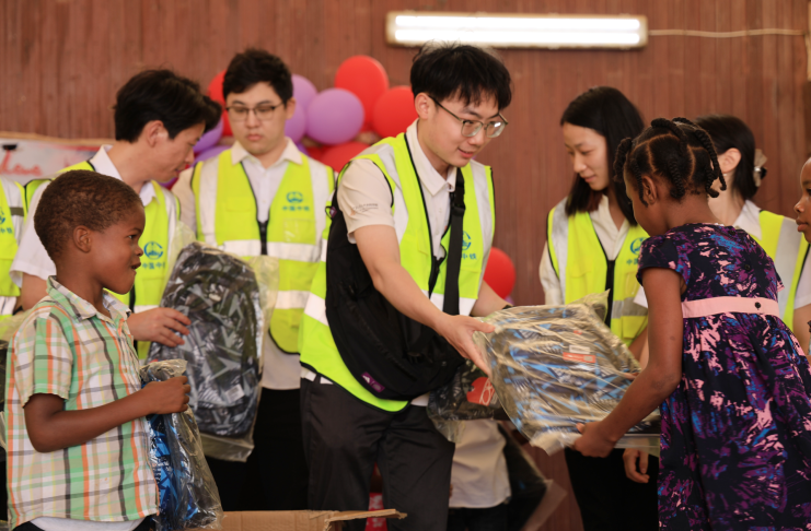 Mr Hu hands out school supplies to students