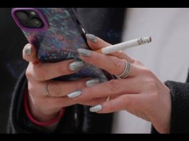 A woman smokes on a street in London on April 16, 2024. (AP Photo/Kin Cheung, File)