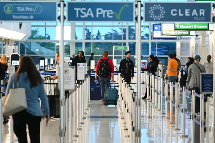 Passengers walk-through security lines at Reagan National Airport on the first day of the US government shut down in Arlington, Virginia on October 1, 2025. (Photo by ANDREW CABALLERO-REYNOLDS / AFP)