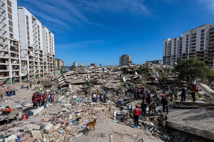Residents on Tuesday search through the rubble of a building that collapsed in the June 24 earthquakes in La Guaira, Venezuela. Ariana Cubillos/AP